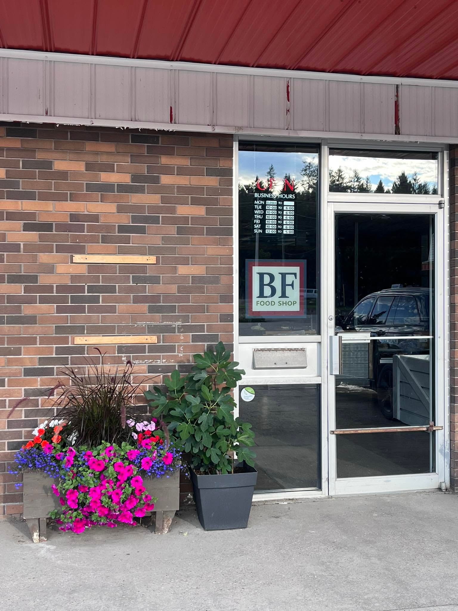 Brickfront Food Shop entrance with BF Food Shop sign and flower planters